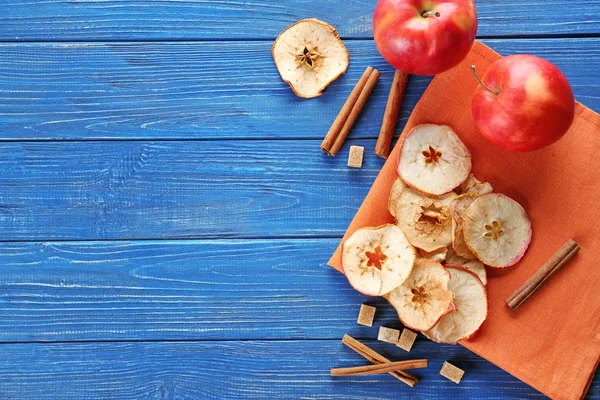 Composition with tasty apple chips on wooden background, top view