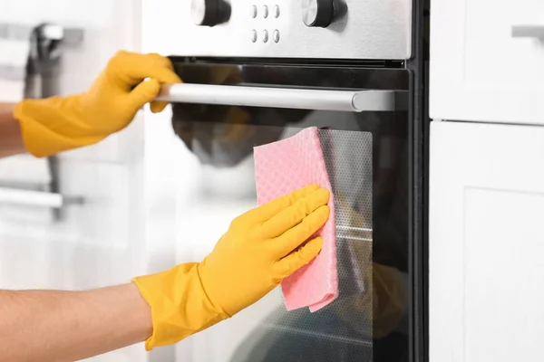 Man cleaning oven in kitchen, closeup — Stock Photo, Image
