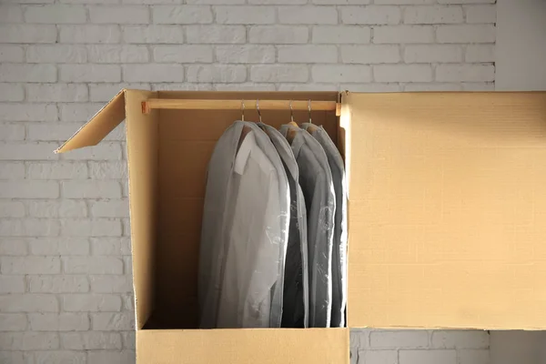 Kleiderschrank mit Kleidung in der Nähe der Ziegelwand — Stockfoto
