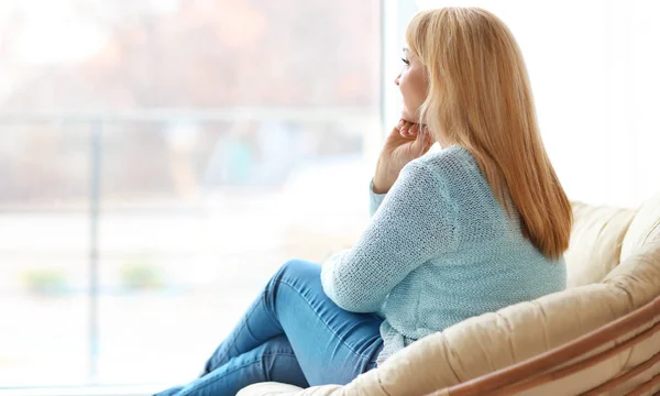 Mulher madura feliz relaxando em poltrona em casa — Fotografia de Stock