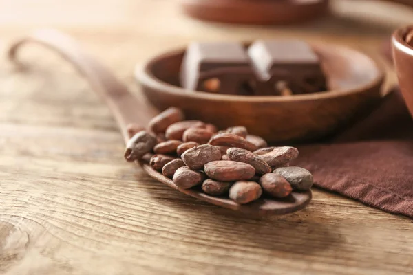 Sendok dengan biji kakao di atas meja, tutup — Stok Foto