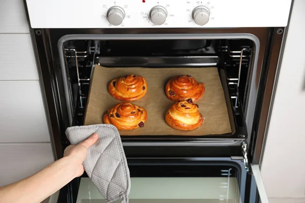 Vrouw nemen broodjes uit de oven — Stockfoto
