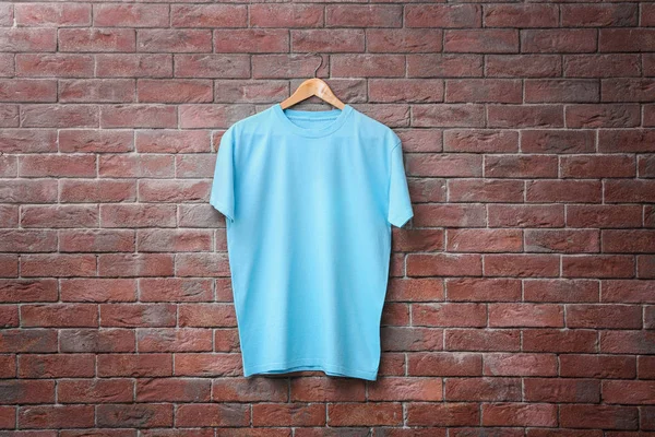 Camiseta azul sobre fondo de pared de ladrillo. Prepárate para el diseño — Foto de Stock