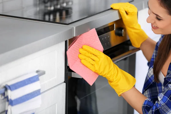 Woman cleaning oven in kitchen, closeup — Stock Photo, Image