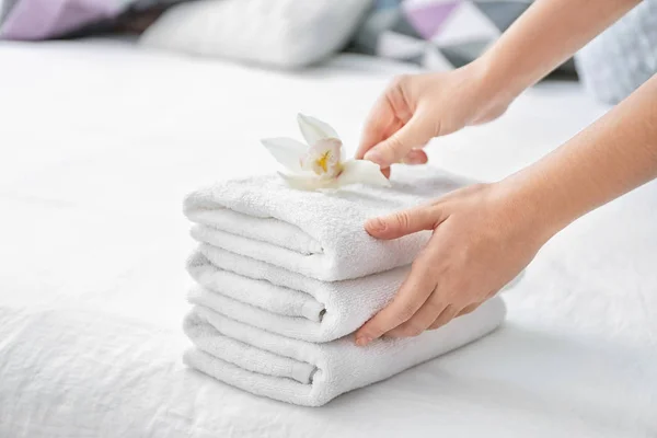 Kvinna med trave rena handdukar på sängen — Stockfoto