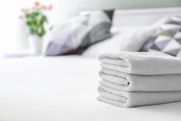 Stack of clean towels on bed — Stock Photo, Image