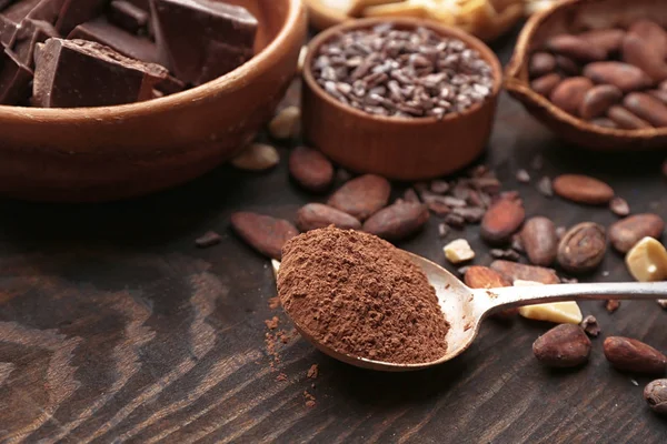 Cuchara con cacao en polvo sobre mesa de madera —  Fotos de Stock