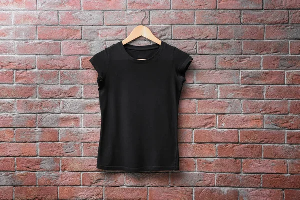 Camiseta negra sobre fondo de pared de ladrillo. Prepárate para el diseño —  Fotos de Stock