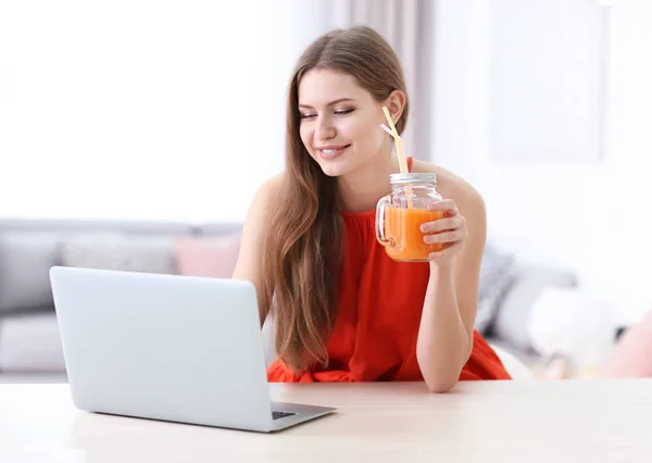 Mujer joven usando el ordenador portátil en el interior — Foto de Stock
