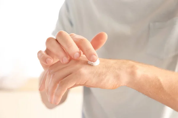 Man toepassen van handcrème thuis, close-up — Stockfoto