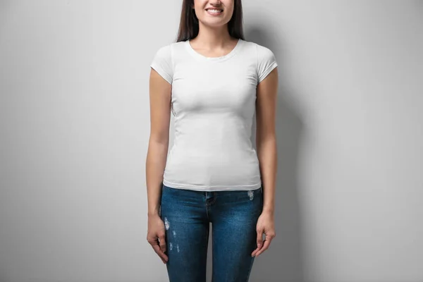 Vrouw in wit t-shirt op lichte achtergrond. Bespotten voor ontwerp — Stockfoto