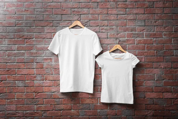Bílá trička na cihlovou zeď na pozadí. Makety pro design — Stock fotografie