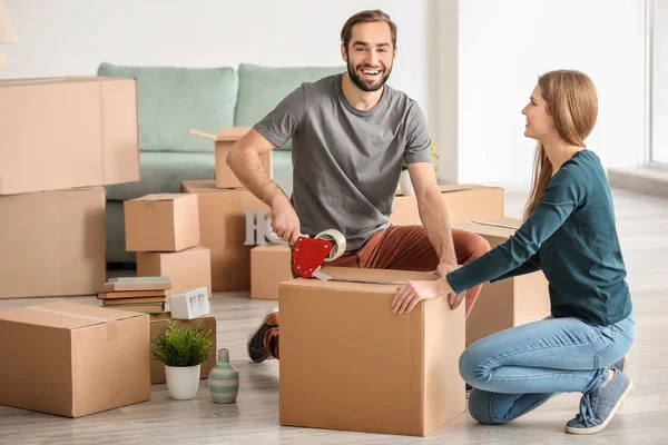 Pareja joven empacando cajas móviles, en interiores — Foto de Stock