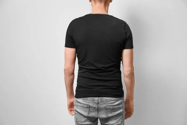 Człowiek w czarny t-shirt, na jasnym tle. Makieta do projekt — Zdjęcie stockowe