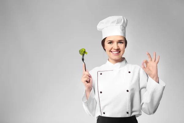 Portrait of female chef on grey background — Stock Photo, Image
