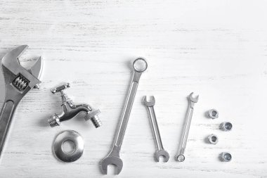 Plumber's tools on wooden background clipart