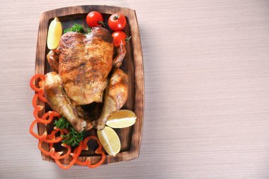 Sebze ile lezzetli bütün kavrulmuş tavuk üzerinde ahşap kurulunda görev yapmaktadır.