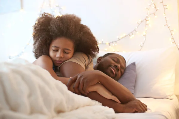 Hombre afroamericano durmiendo con su hija en la cama. Hora de dormir familiar —  Fotos de Stock