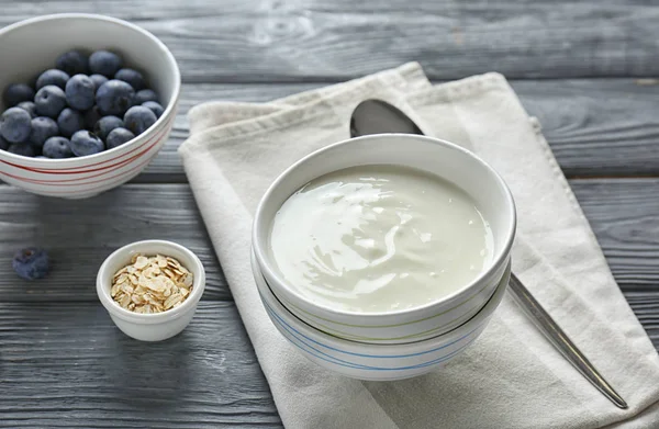 Lekkere yoghurt in schotel op houten tafel — Stockfoto