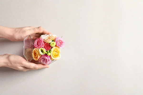 Woman holding box with beautiful roses on light background — Stock Photo, Image