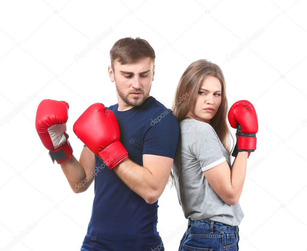 Unhappy couple in boxing gloves on white background. Problems in relationship
