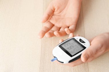 Açık renkli dijital Şeker Ölçüm kullanan kadın. Diyabet kontrolü