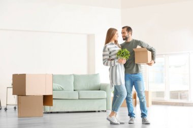 Genç adam hareketli kutusu ve kadın ile houseplant odasında yeni bir ev tutarak