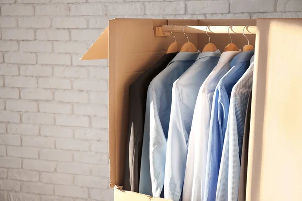 Wardrobe box with clothes near brick wall — Stock Photo, Image