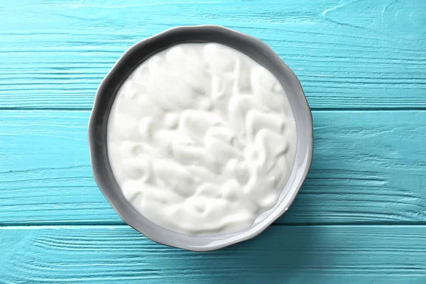 Tasty yogurt in dish on wooden table — Stock Photo, Image