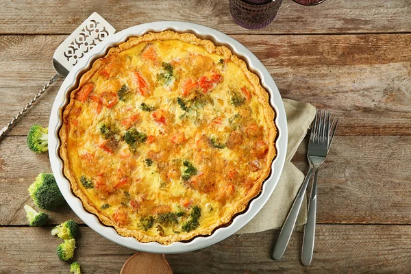 Baking dish with tasty broccoli quiche on table — Stock Photo, Image