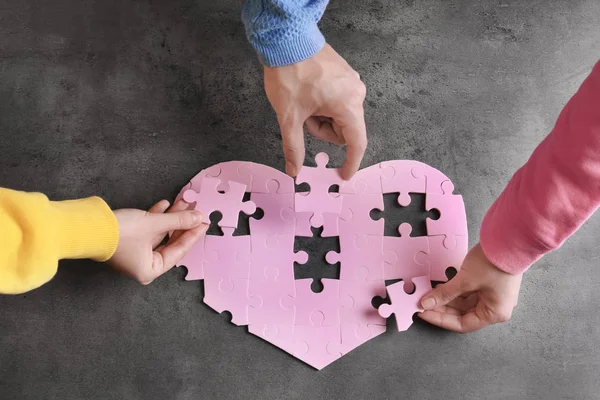 People completing puzzle together — Stock Photo, Image