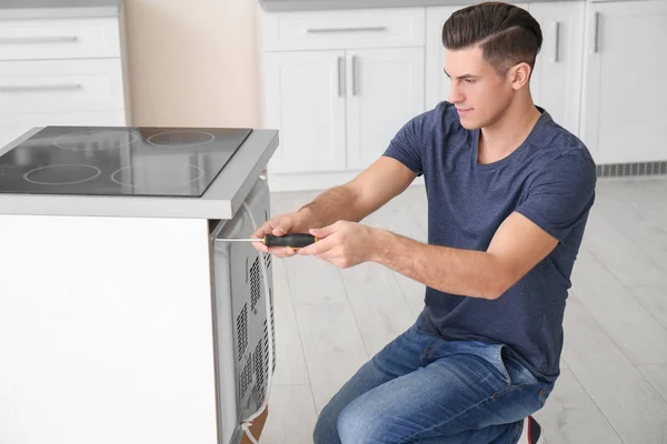 man repairing oven