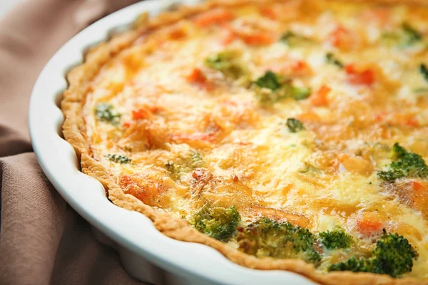 Baking dish with tasty broccoli quiche on table, closeup — Stock Photo, Image
