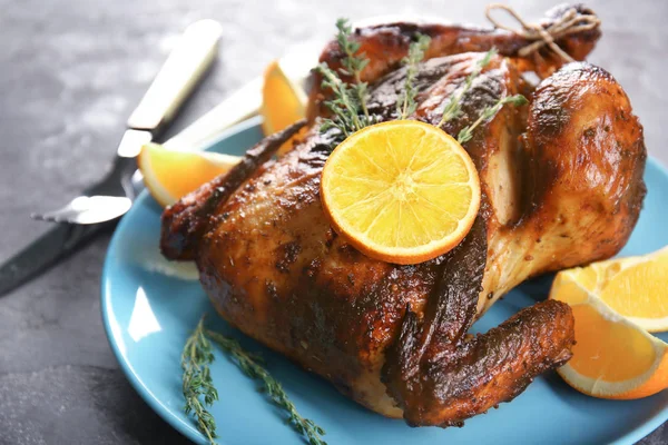 Delicious whole roasted chicken with orange served on plate — Stock Photo, Image
