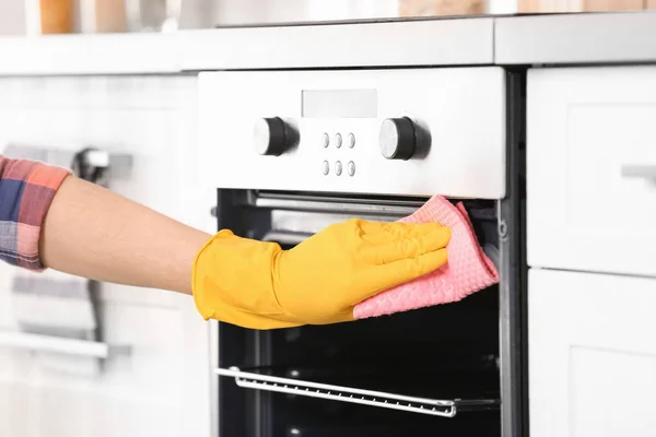 Man cleaning oven in kitchen, closeup — Stock Photo, Image