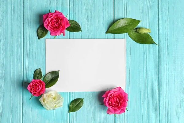 Beautiful roses and empty card on wooden background — Stock Photo, Image