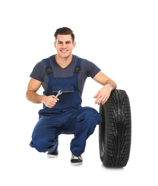 Joven mecánico con neumático de coche — Foto de Stock