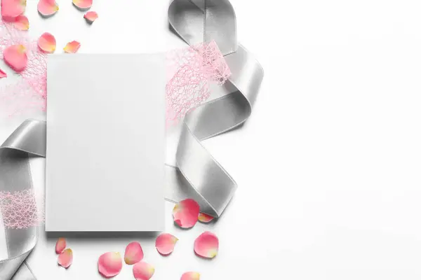 Petali di rosa, nastri e carta vuota su sfondo chiaro — Foto Stock