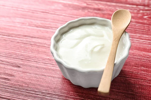 Tasty yogurt in dish on wooden table — Stock Photo, Image