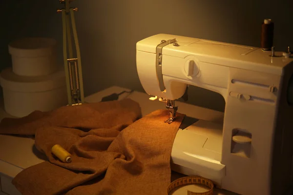 Пошивний стіл з сучасною швейною машиною — стокове фото