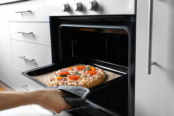 Vrouw pizza aanbrengend oven — Stockfoto