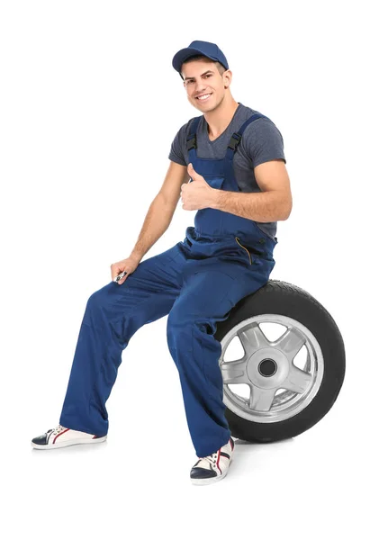 Jeune mécanicien avec pneu voiture — Photo