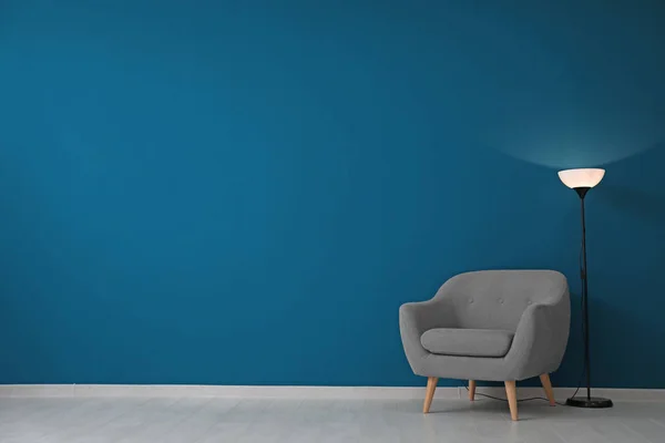 Schöner Sessel und Stehlampe in der Nähe der Wand — Stockfoto