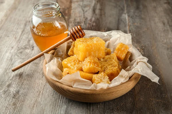 Pot met zoete honing en kammen op houten tafel — Stockfoto