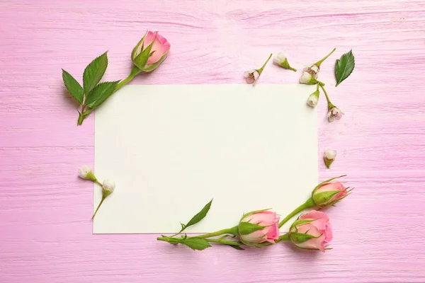 Cartão em branco e flores em fundo de madeira — Fotografia de Stock