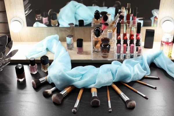 Cosmética decorativa y herramientas en tocador cerca del espejo en la sala de maquillaje —  Fotos de Stock
