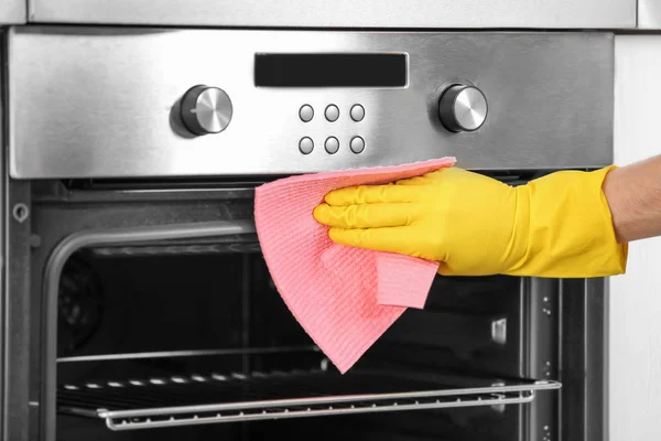 Man cleaning oven in kitchen, closeup — Stock Photo, Image