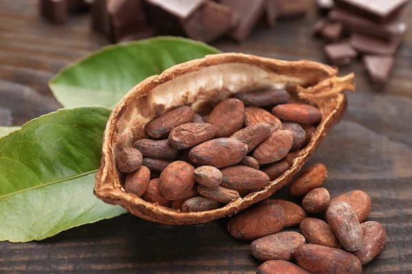 Mitad de vaina de cacao con frijoles en mesa de madera — Foto de Stock