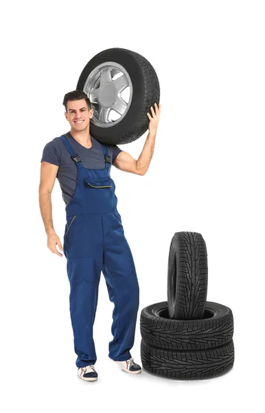 Jovem mecânico com pneus de carro — Fotografia de Stock