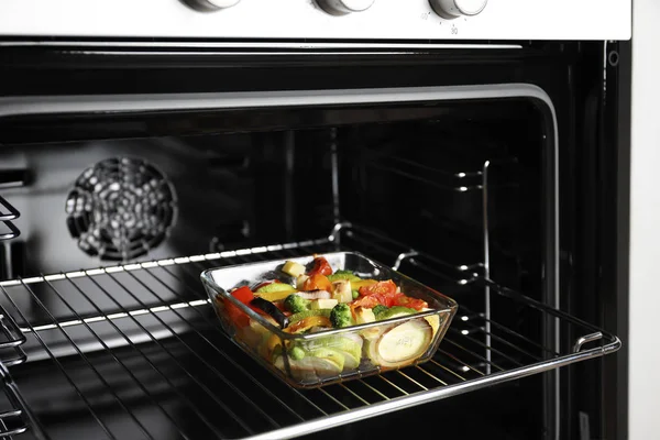 Glass baking dish with vegetables in oven — Stock Photo, Image